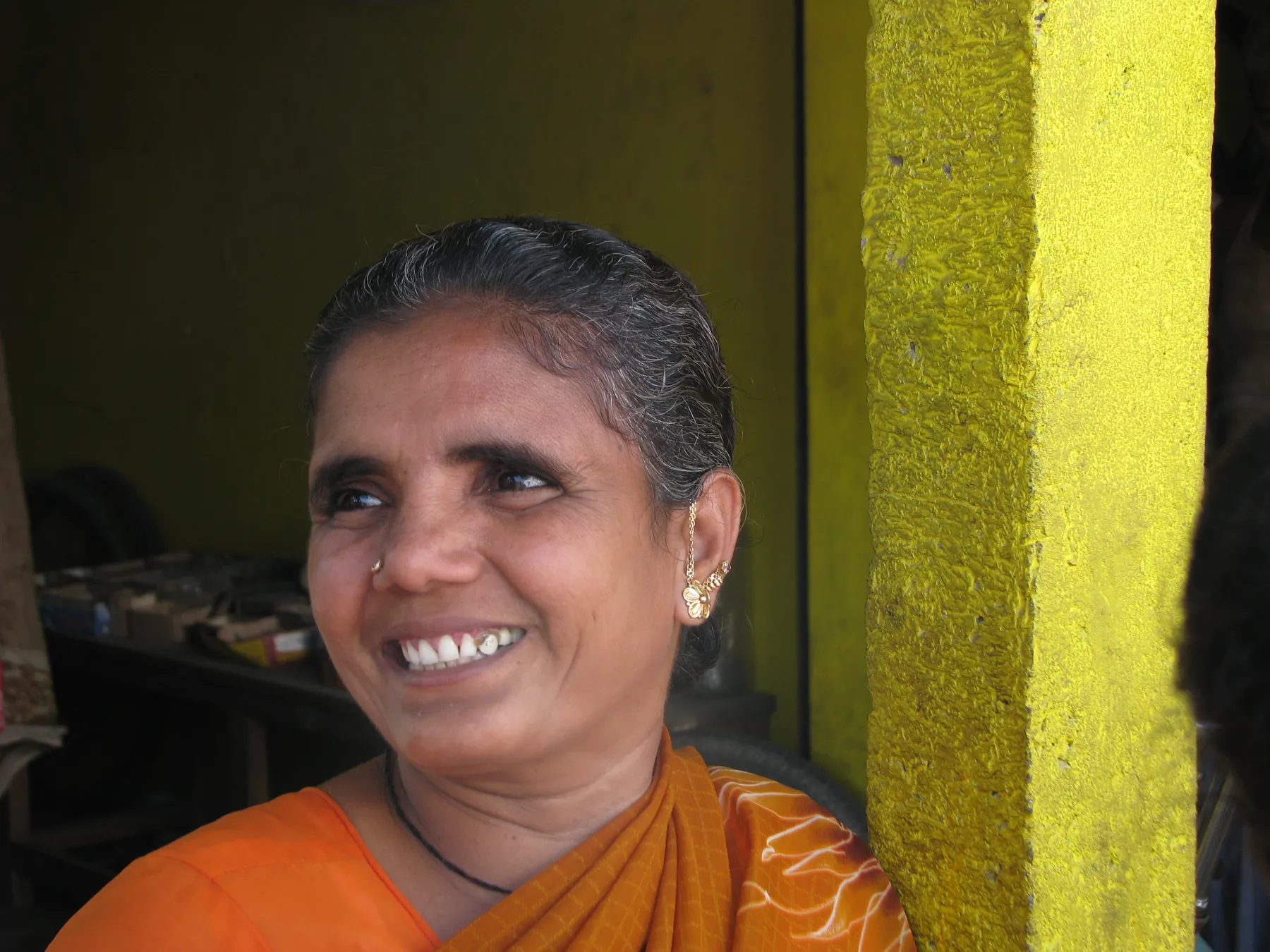 A smiling bike shop owner standing in her workshop doorway